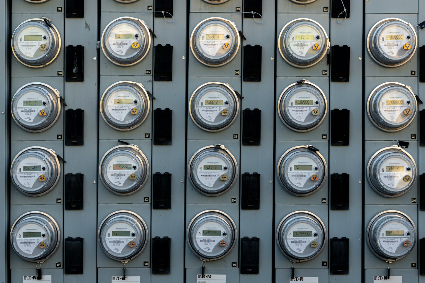 Rijen elektriciteitsmeters gemonteerd op een industrieel paneel.