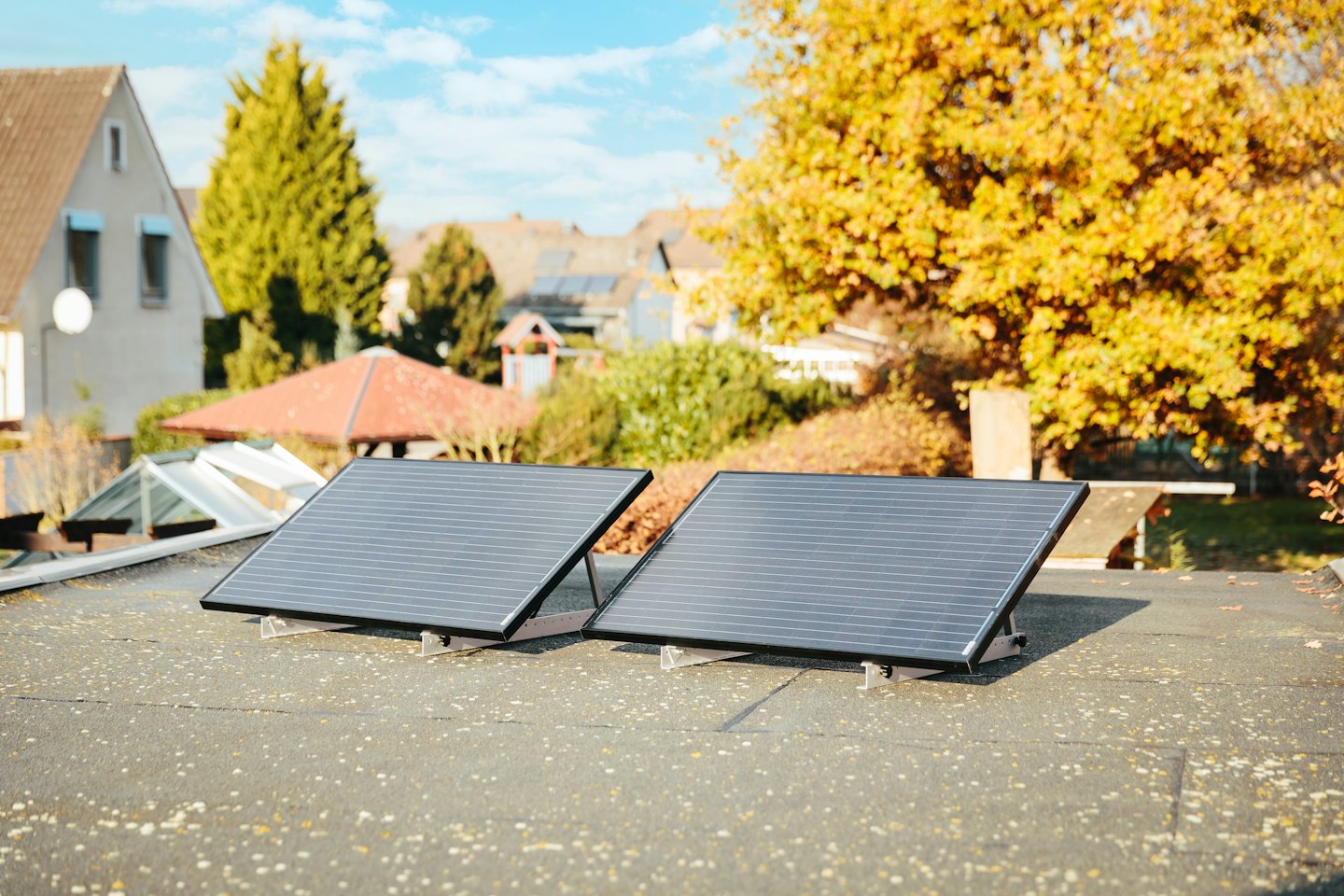 Twee zonnepanelen op een dak onder felle zon.